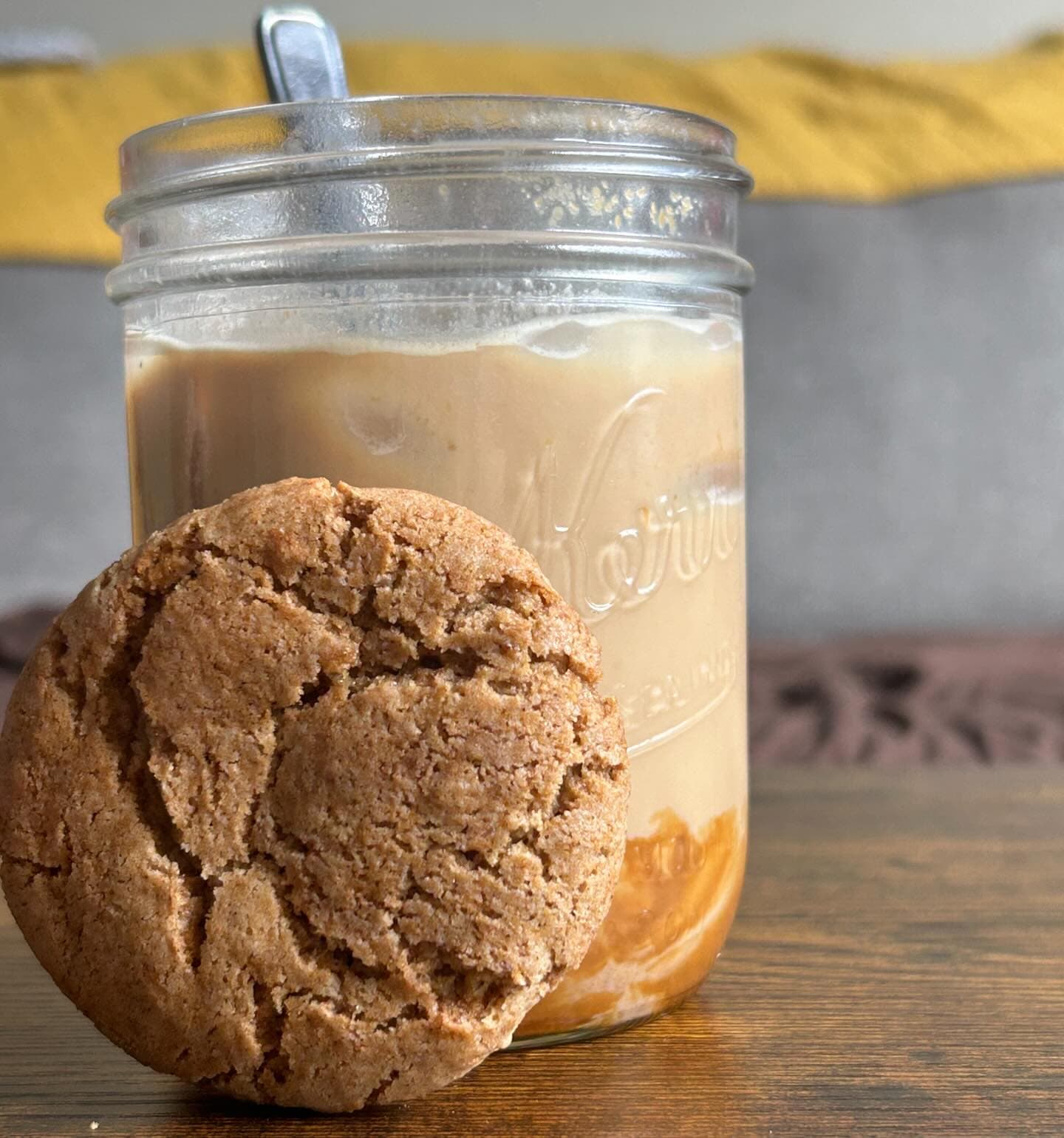 A homemade cookie beside an iced coffee in Mya's kitchen