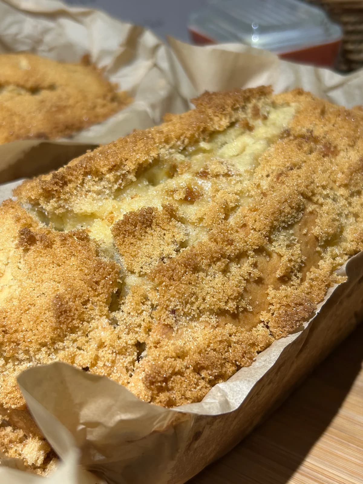 Golden homemade banana bread with a crisp, crumbled crust in parchment
